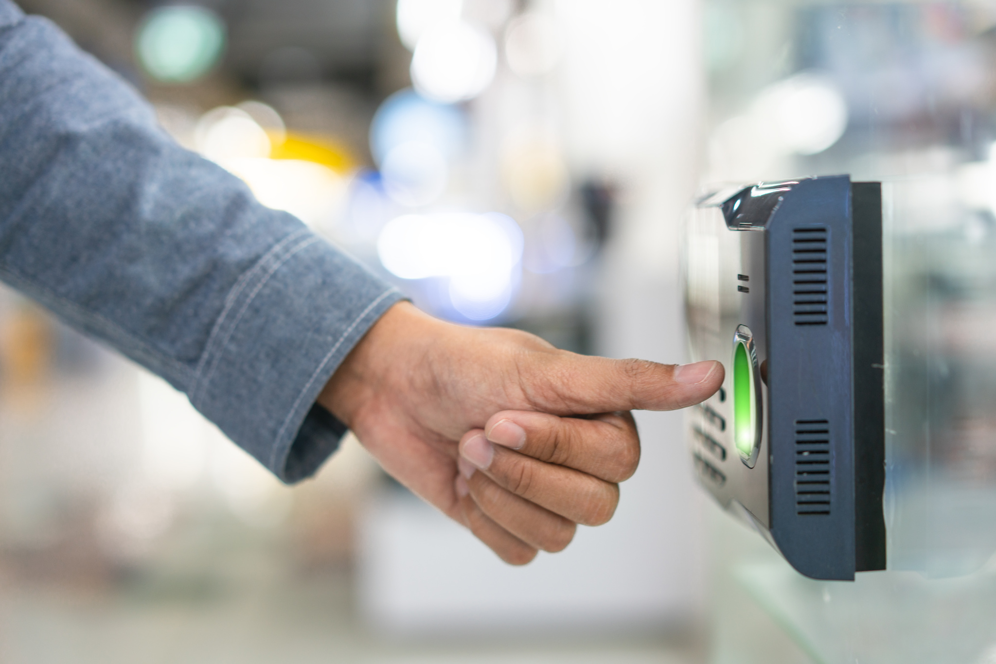 Employee scanning fingerprint record hours work time.
